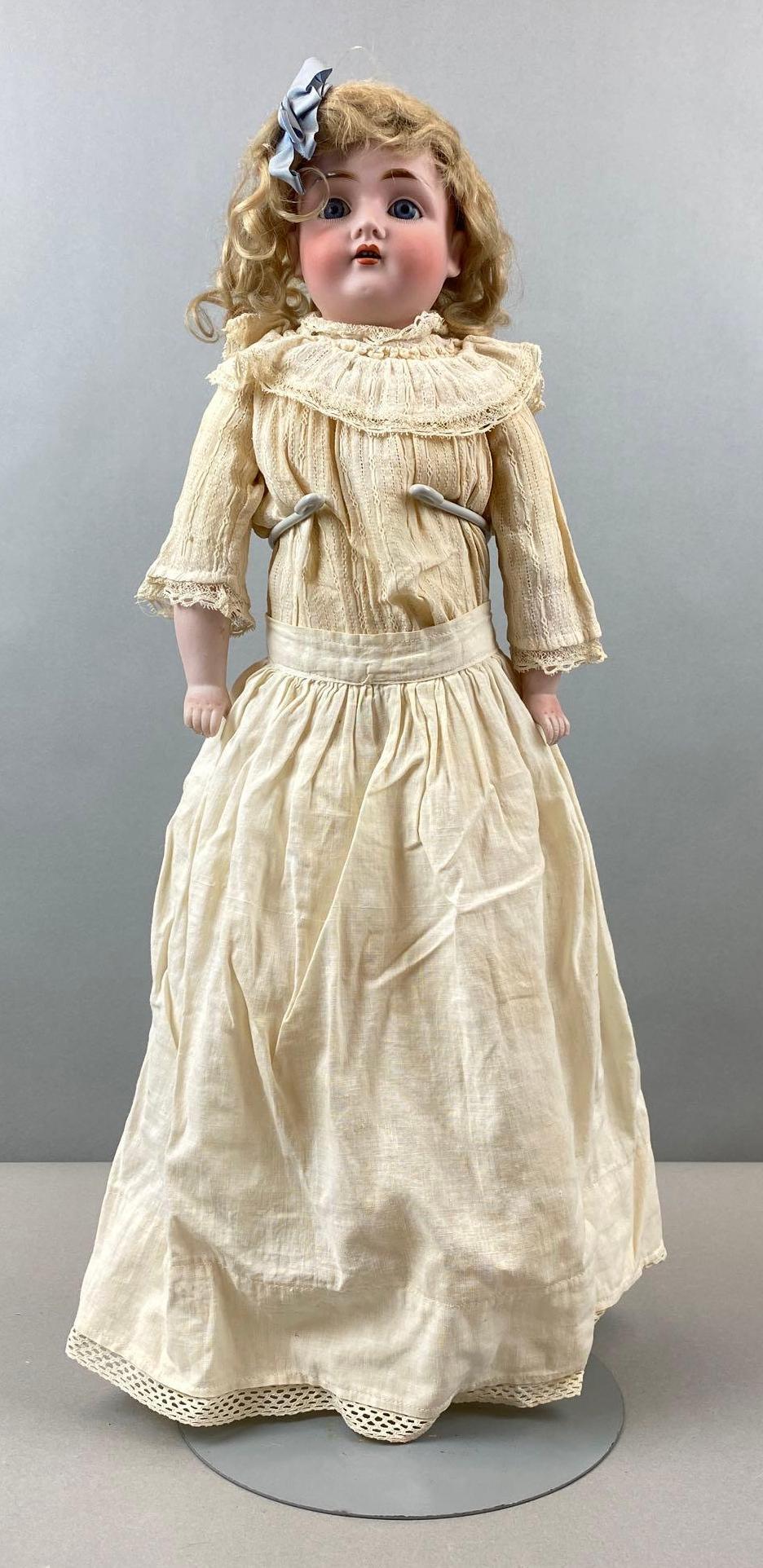 Antique Bisque Doll: Back of head is marked. Sleepy eyes. 19 1/2 inches tall. Doll stand not included.