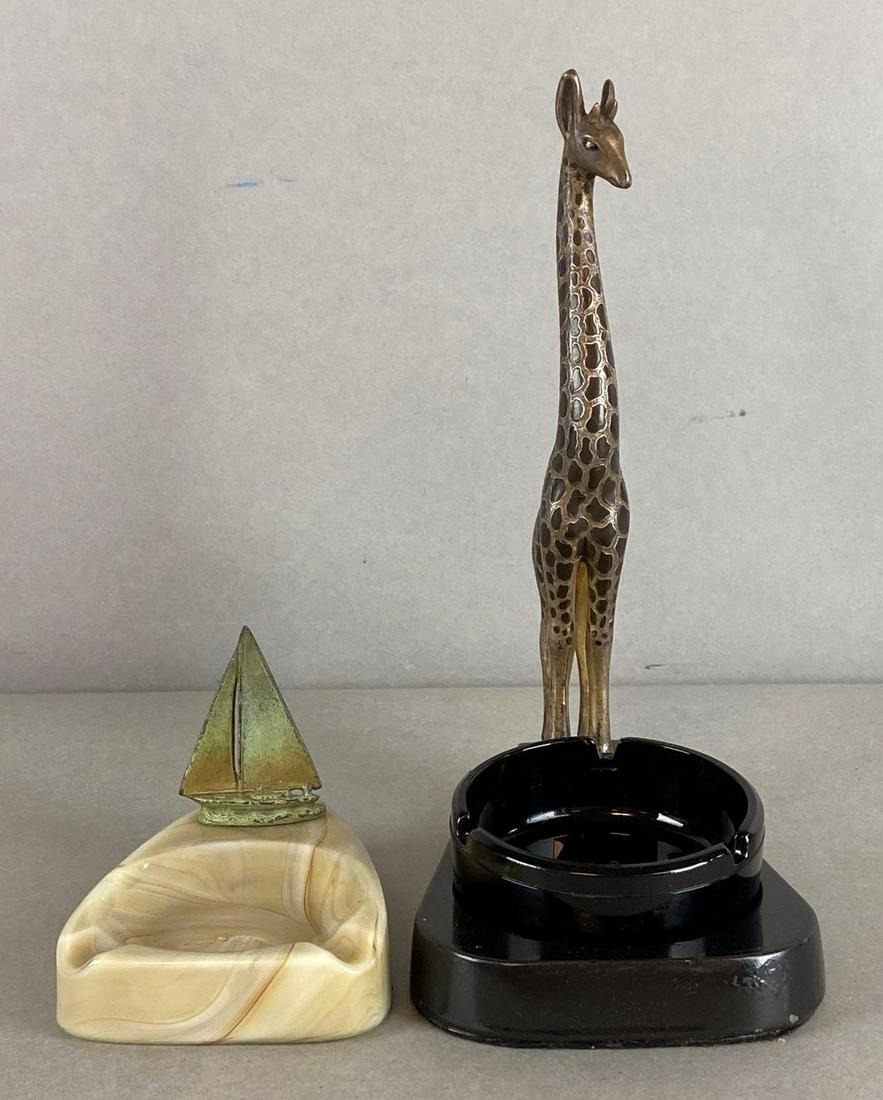 Group of 2 Glass Ashtrays With Figures: Includes sailboat, and giraffe, Giraffe ashtray separate from base, Largest measures 9 3/4 x 4 1/2 x 7in.