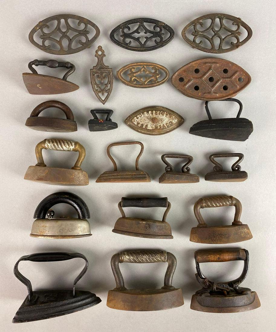 Group of 21 Cast Iron Sad Irons and Trivets: 6 trivets, rust, discoloration, largest measures 3 X 4 1/2 X 2 3/4 inches