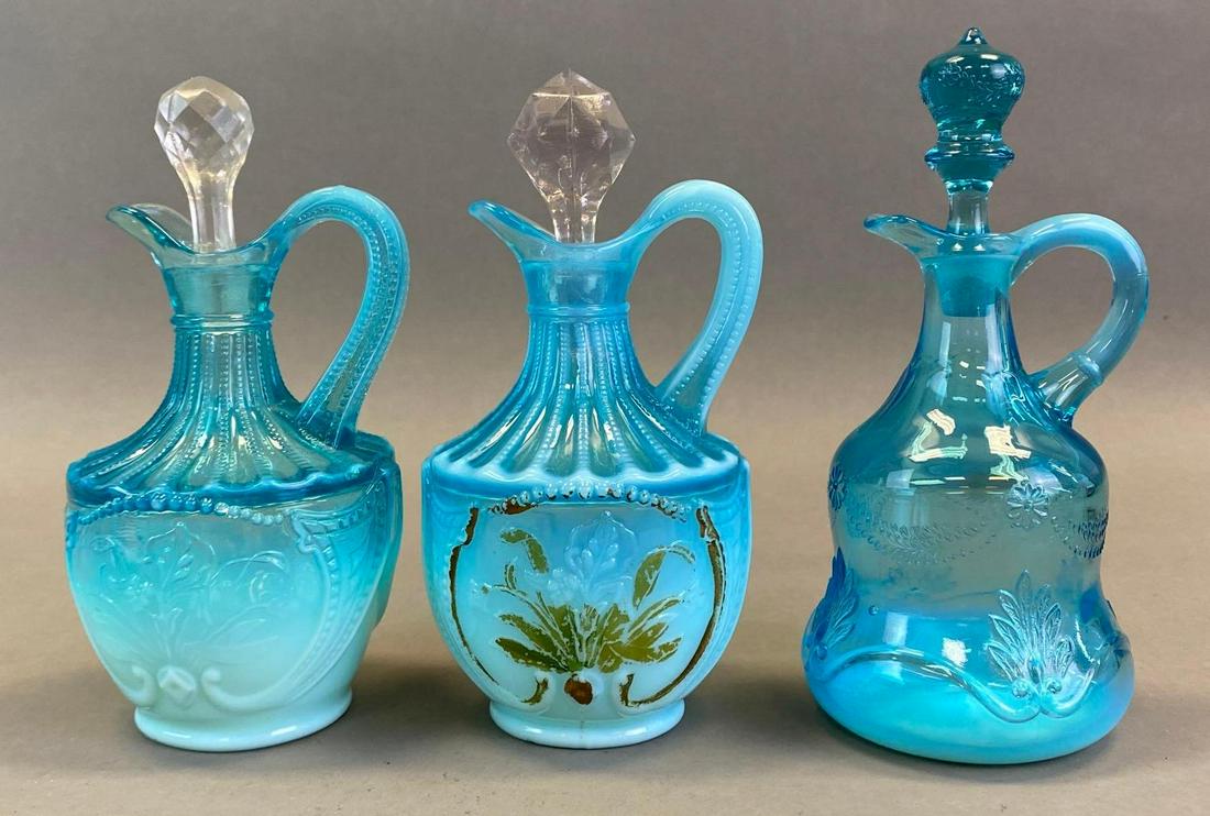 Group of 3 Victorian Blue Embossed Opalescent Glass Cruets: All with floral and foliage motifs, one hand painted, Tallest measures 7 3/4 x 3 1/4 x 3 1/4in with stopper.
