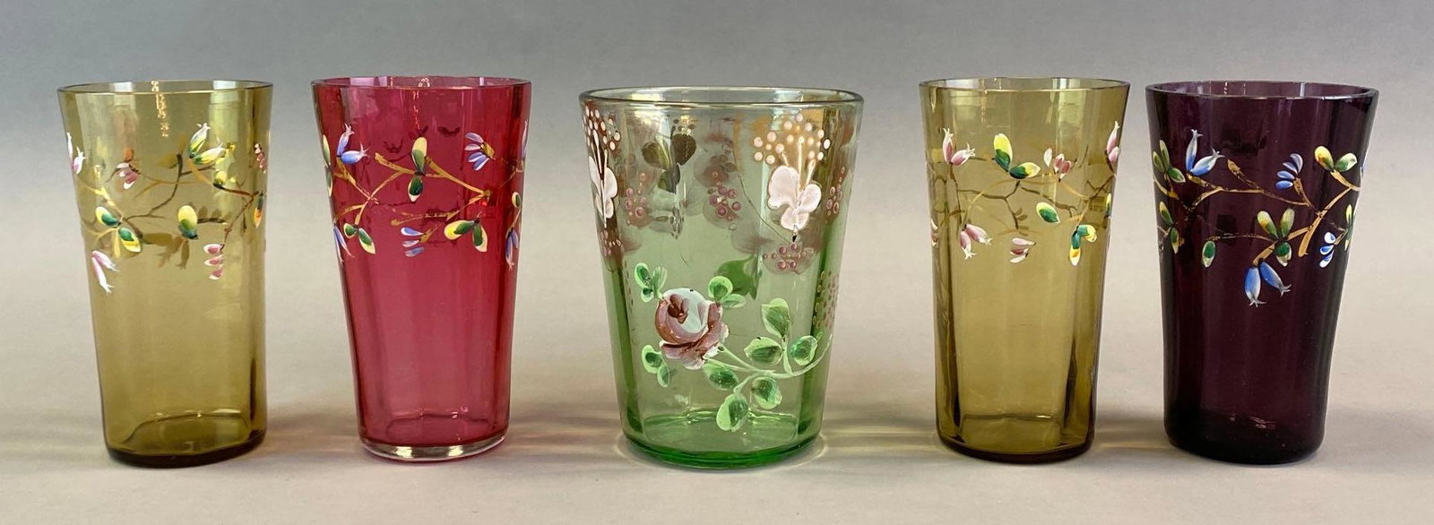 Group of 5 Moser Optic Floral Enamel Glass Tumblers: Hand painted, includes amber, green, pink, and amethyst, Some small chips on rims, Largest measures 4 x 3 x 3in.