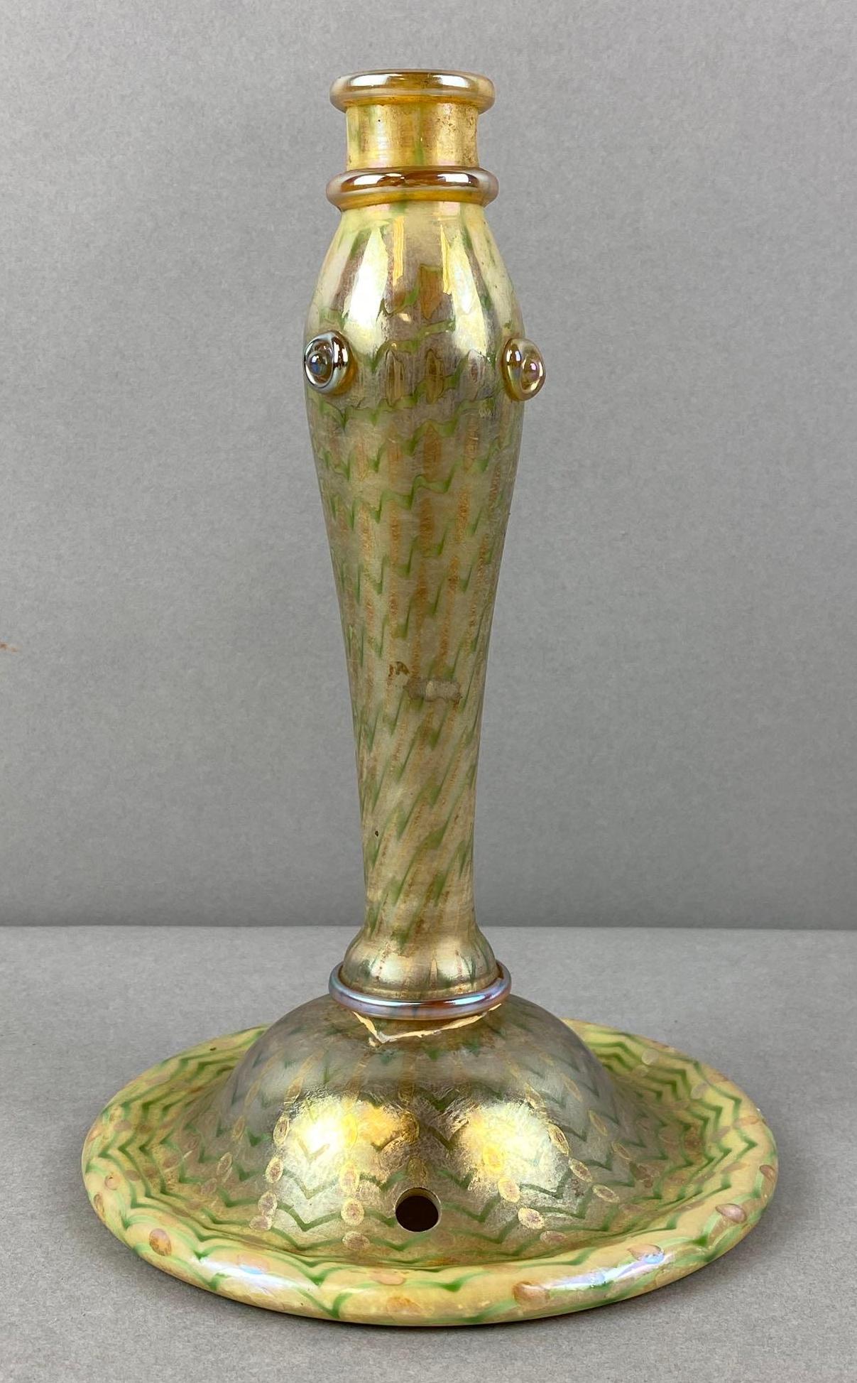 LC Tiffany Fauville Green and Yellow Iridescent Glass Candlestick: Hole has been drilled into base, potentially to be converted to lamp. Measures 8 x 5 inches. Small chip, marked on bottom, repairs on base