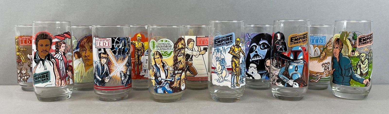 Group of 12 Vintage Star Wars Advertising Collector Glasses: Burger King and Coca Cola, 1977, 1980, 1983. Includes Han Solo, Luke skywalker, Darth Vader, Chewbacca, and more. Each measure 5 1/2 x 2 7/8 inches