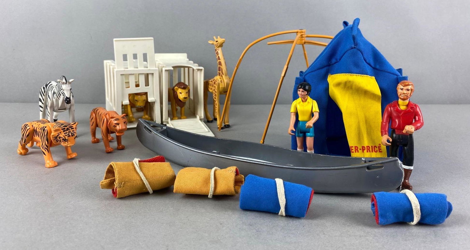 Group of 15+ Vintage Fisher Price Adventure People Toys: Unknown set completion. Includes lions, tigers, tent, boat, and more. Boat measures 10 x 2 1/2 x 1 1/2 inches
