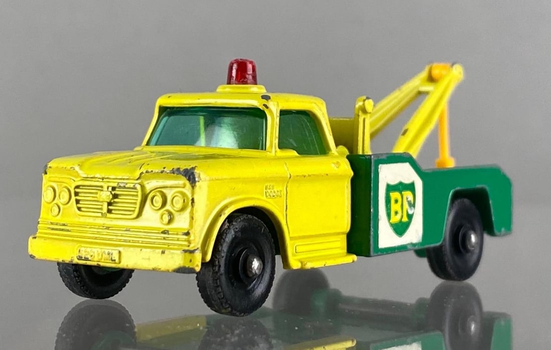 Matchbox No. 13 Dodge Wrecking Truck: Lesney, Made in England. Color: Green and Yellow, Blue Windows, Black Plastic Wheels, Green Base, Red Siren, Die-Cast.