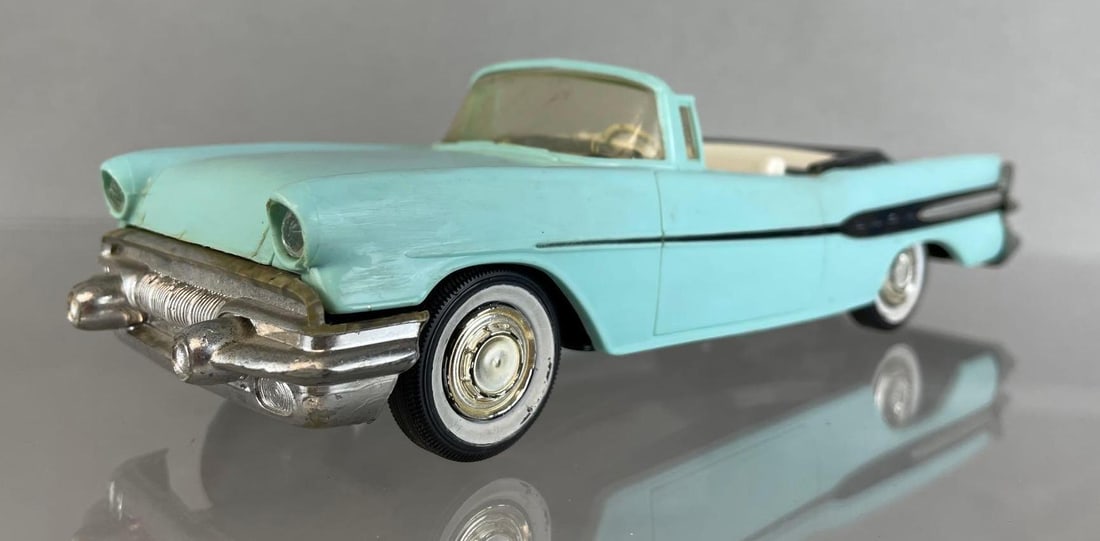 1957 Pontiac Star Chief Convertible Dealership Promo Car: light blue with white and gray interior, friction but missing motor, broken steering wheel, top windshield frame broken, some warpage and discoloration. Measures 8 1/2 x 3 x 2 1/4 inches