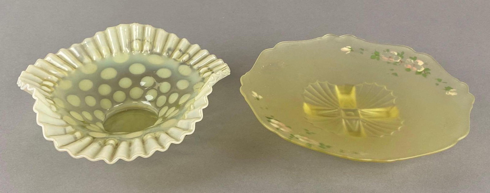 Group of 2 Yellow Glass Dishes: Includes Dotted Ruffle Ribbon edge shallow glass bow, and Handpainted floral satin glass platter, Some small flaws and fleabites, Largest measures 10 1/2 x 10 1/2 x 2 inches.