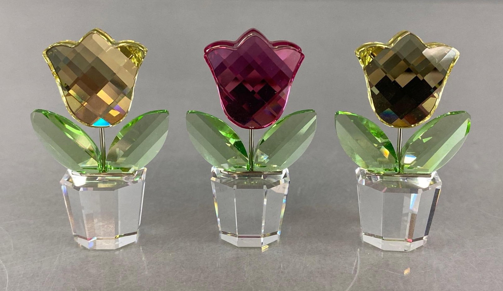 Group of 3 Swarovski Crystal Tulips with Boxes: 2003, Includes (2) yellow and (1) pink, Pink box without protective foam, (2) with certificates, Figures measure 2 x 1 1/4 x 3/4 inches, Boxes measure 3 x 3 x 1 1/2 inches.