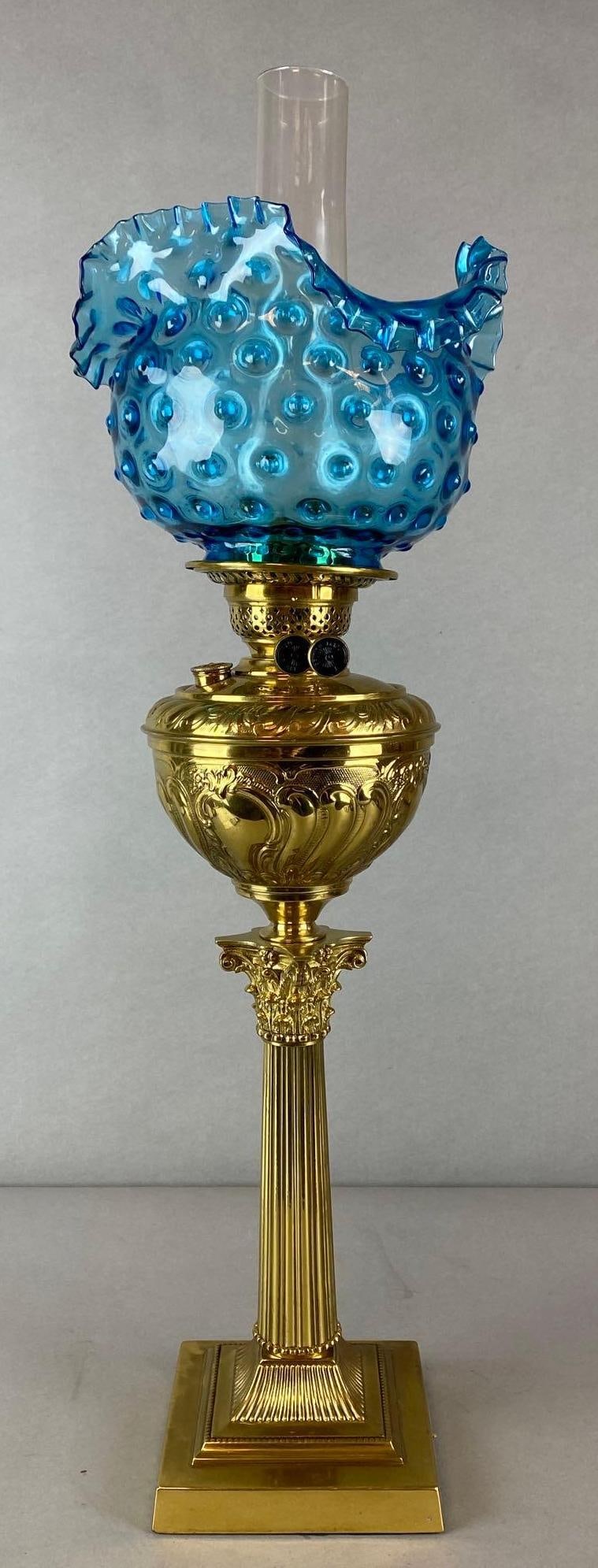 British Made Brass Oil Lamp With Blue Hobnail Glass Shade: Blue ruffle ribbon edge shade, Some fleabites around rims, Measures 29 1/2 x 10 x 10 inches.