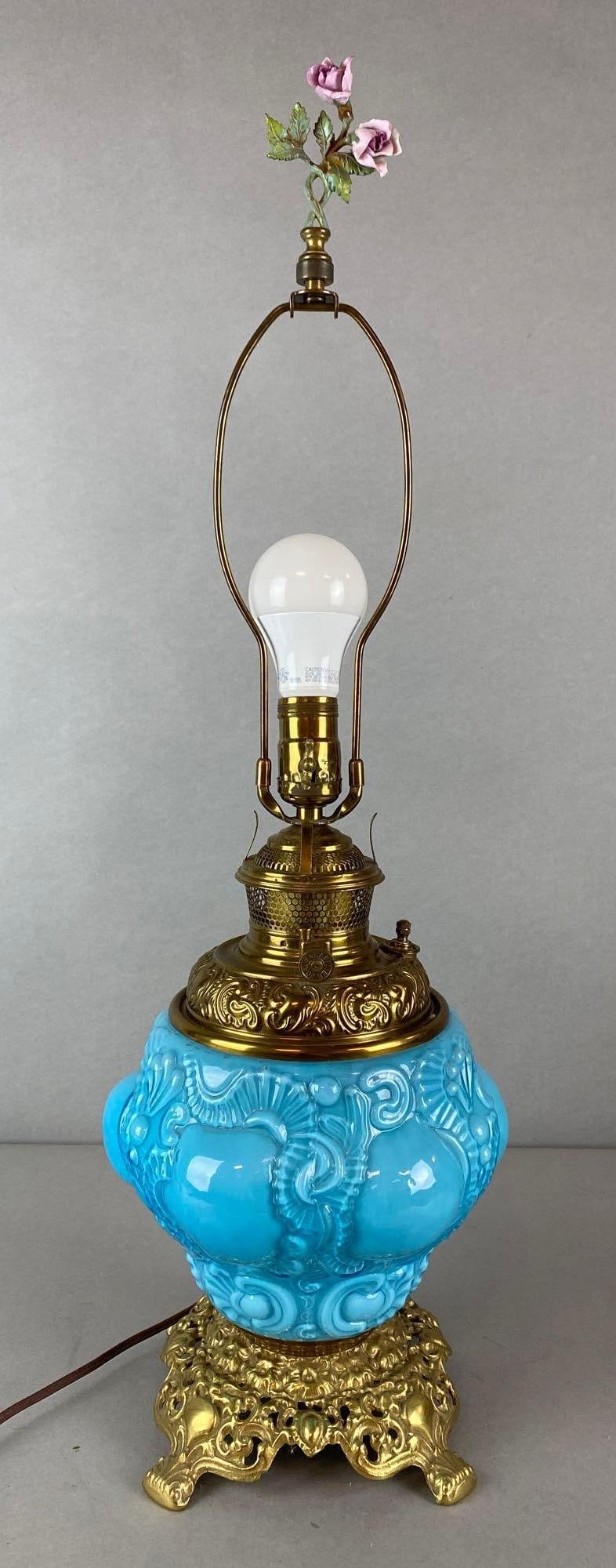 Blue to Clear Cased Glass Electrified Tabletop Oil Lamp: Electrified, In working condition, Pressed glass base with brass feet, Base not fully attached to glass, Measures 28 1/2 x 8 x 8 inches.