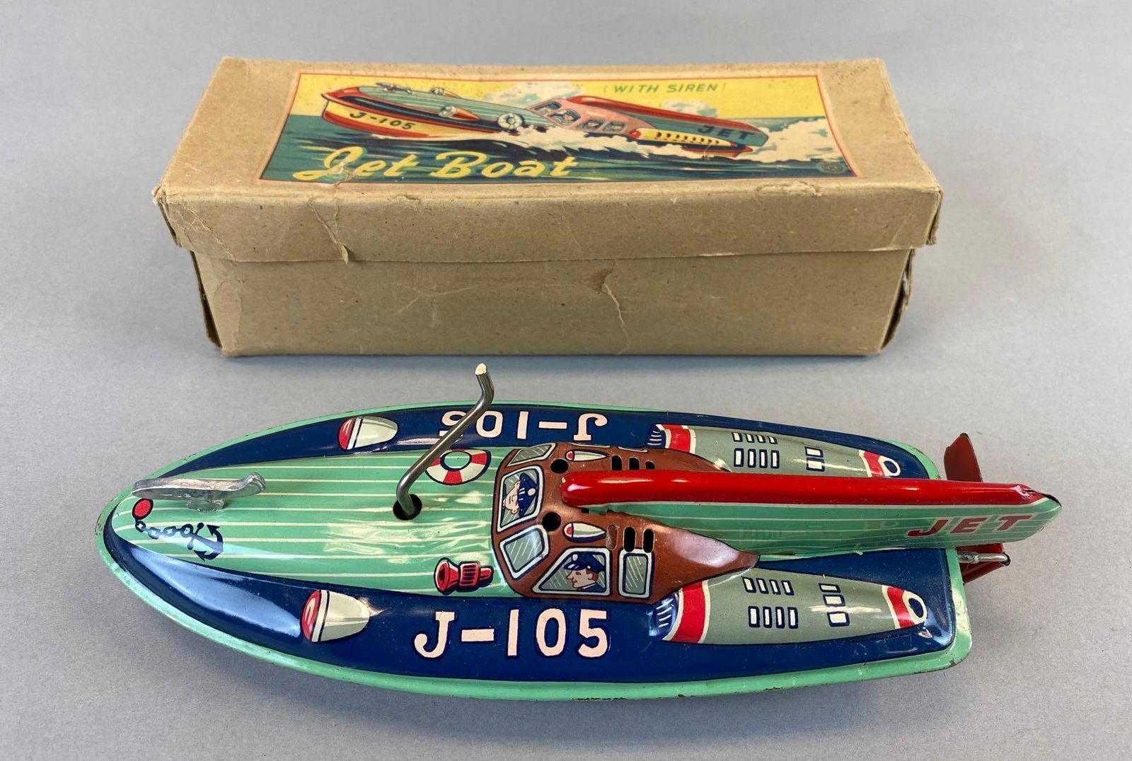 Vintage Windup J-105 Police Tin Litho Jet Boat Space Ship Design: With original box. Japan late 1950s. Some wear. Measures 3 x 9 1/2 x 3 1/2 inches.