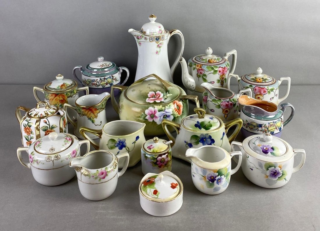 Group of 18 Nippon Porcelain Dishes: Includes teapots, creamers and sugars. Condition consistent with age, largest measures 9 x 6 3/4 x 5 inches
