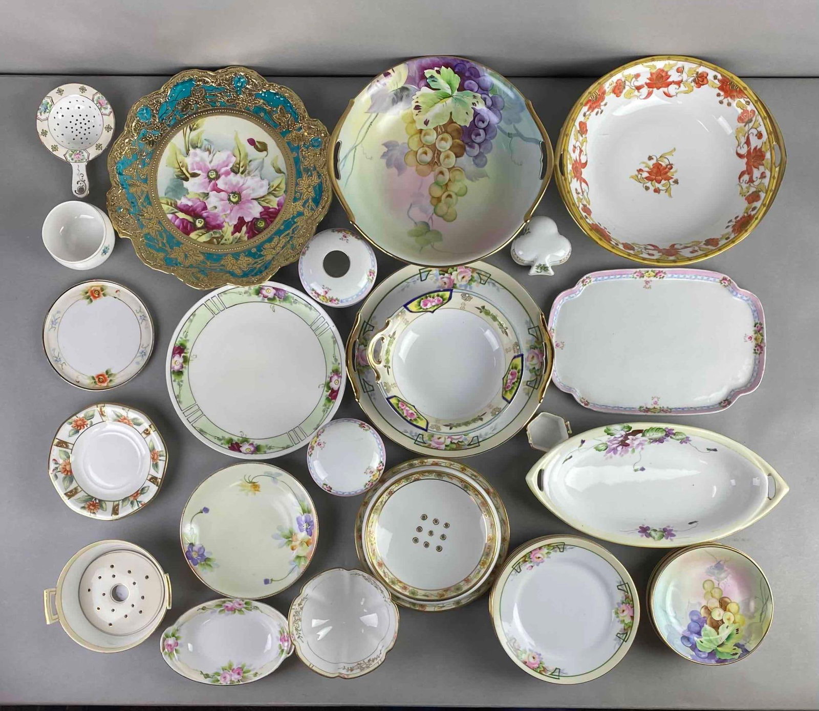 Group of 25+ Nippon Porcelain Dishes: Includes plates, saucers, and more. Condition consistent with age, largest measures 10 1/4 x 9 3/4 x 2 1/4 inches