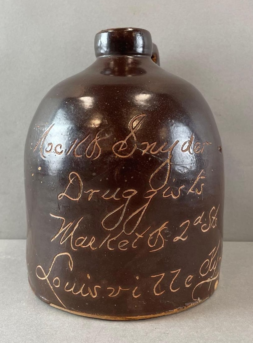 Nock and Snyder Druggists Brown Slip Advertising Scratch Jug: Market and 2nd sts Louisville Ky. Chip on back. Measures 8 x 6 1/4 inches