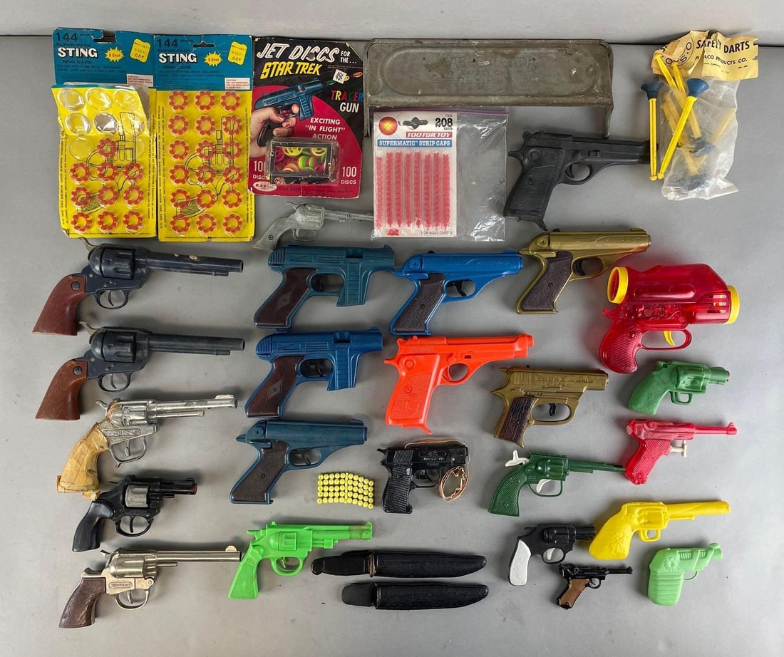 Group of 30+ Toy Guns and More: Includes cap guns, water guns, Star Trek tracer disc guns, and more. Ring cap packages measure 9 1/2 x 4 1/2 inches