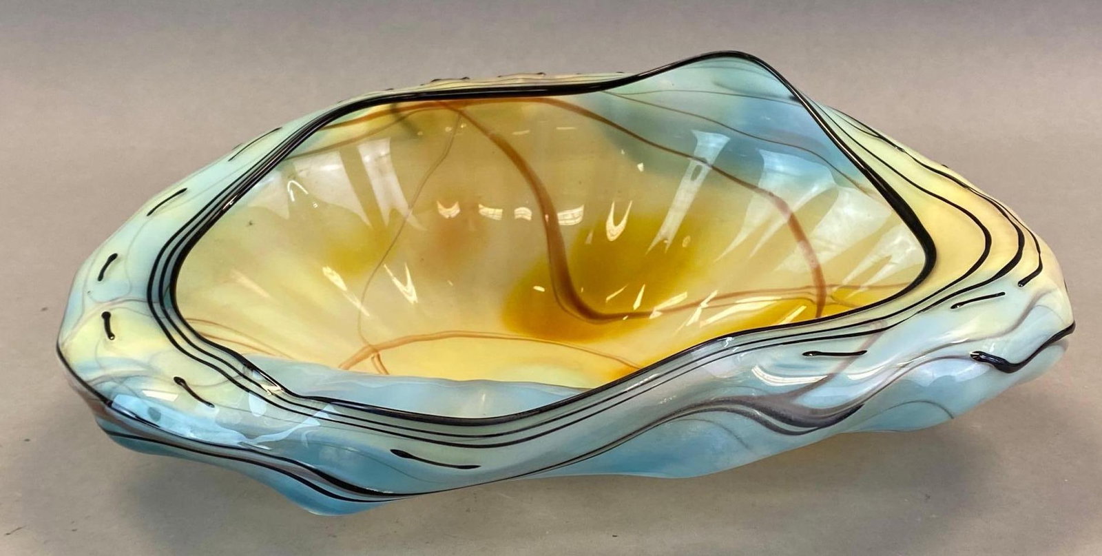 Dale Chihuly Amber and Blue Decorative Art Glass Bowl: 1988, Artist signature on base, American glass artist and entrepreneur, Possibly created during his Seaform or Venetian Art Deco Series, Measures 4 x 10 3/4 x 8 1/2in.