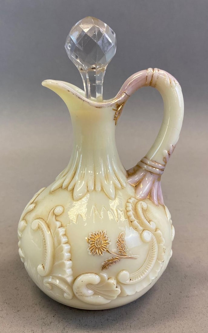 Northwood Glass Co. Ivory Cameo Glass Cruet: With painted gold gilt accents, Some cracks along handle and throughout body, Measures 6 1/4 x 3 3/4 x 3 3/4in with stopper.