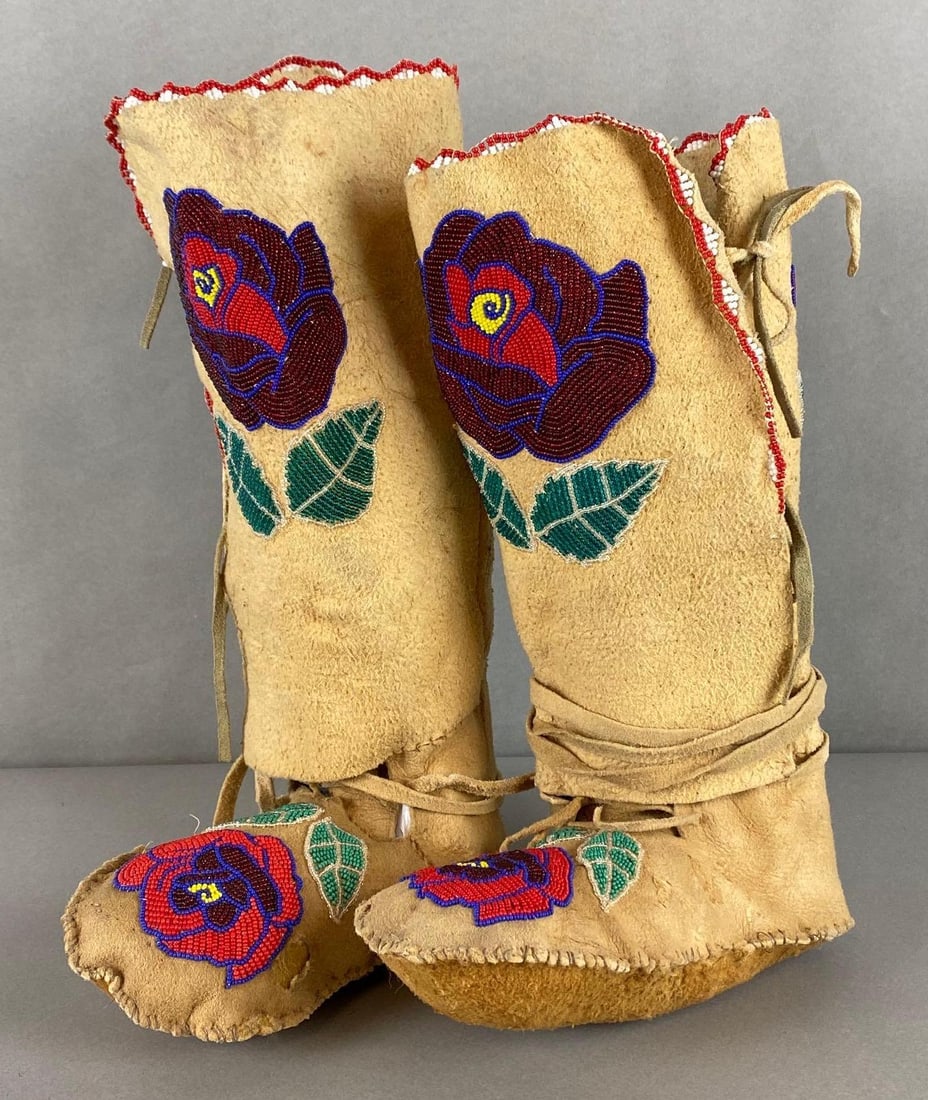 Pair of Beaded Native American High Moccasin Boots: Beaded rose patterns in front and back, Some small holes in both, Both measure approximately 8 1/2 x 13 1/2 x 4 1/2 inches.