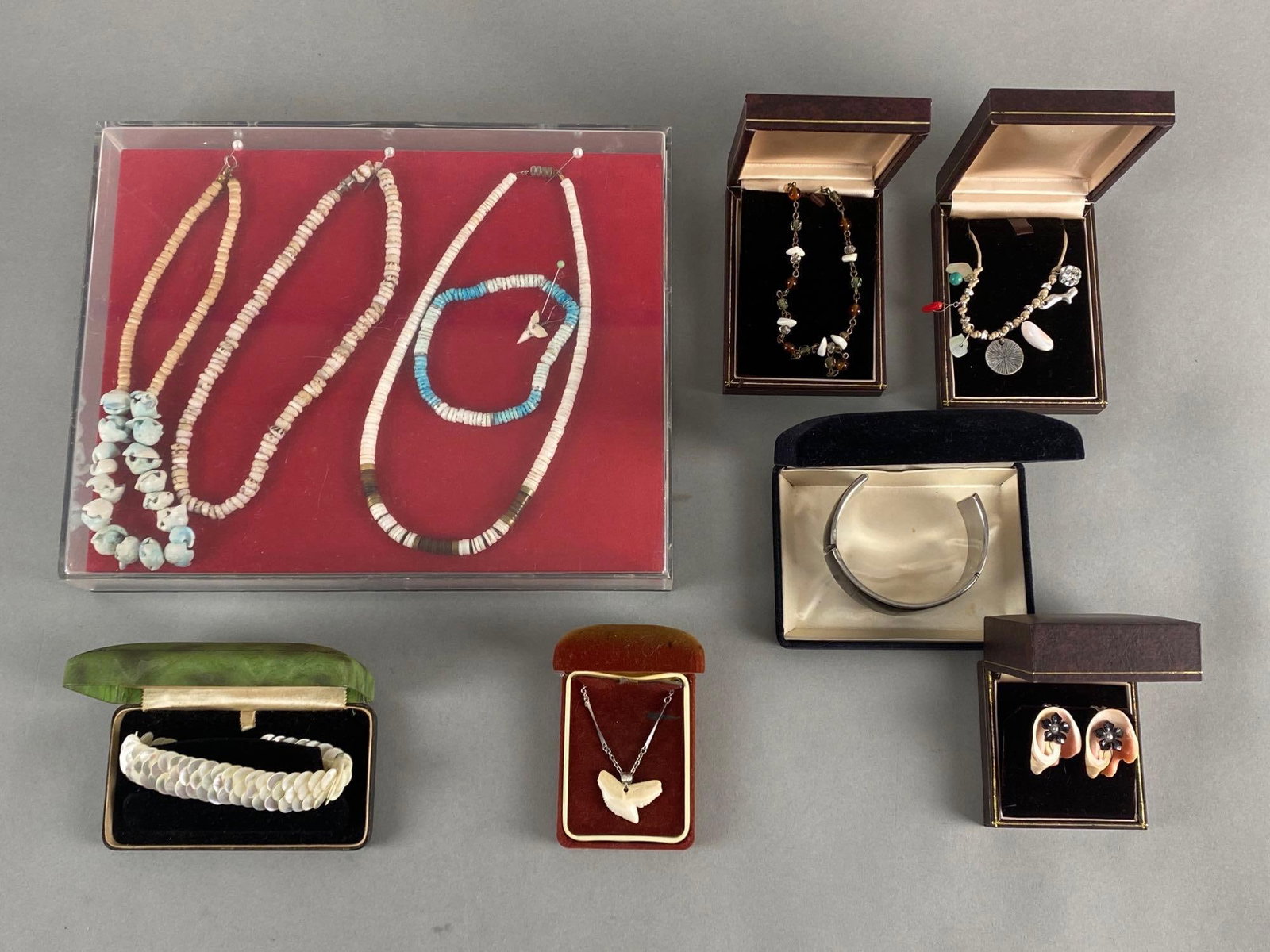 Group of 10 Shell and Shark Tooth Jewelry Items: Includes necklaces, earrings, and bracelets, Longest necklace measures 16 inches long.