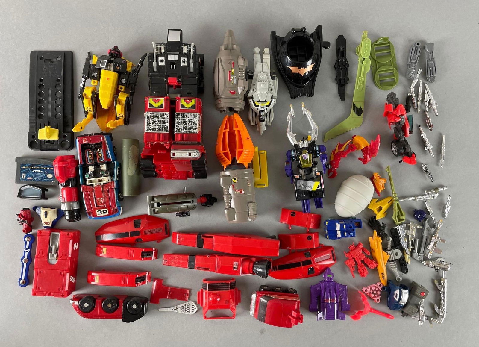 Group of Transformers Parts and Accessories: Includes game boy advance Spider-Man 2, shrapnel, weapons, and more. Largest measures 7 1/2 x 4 x 3 inches