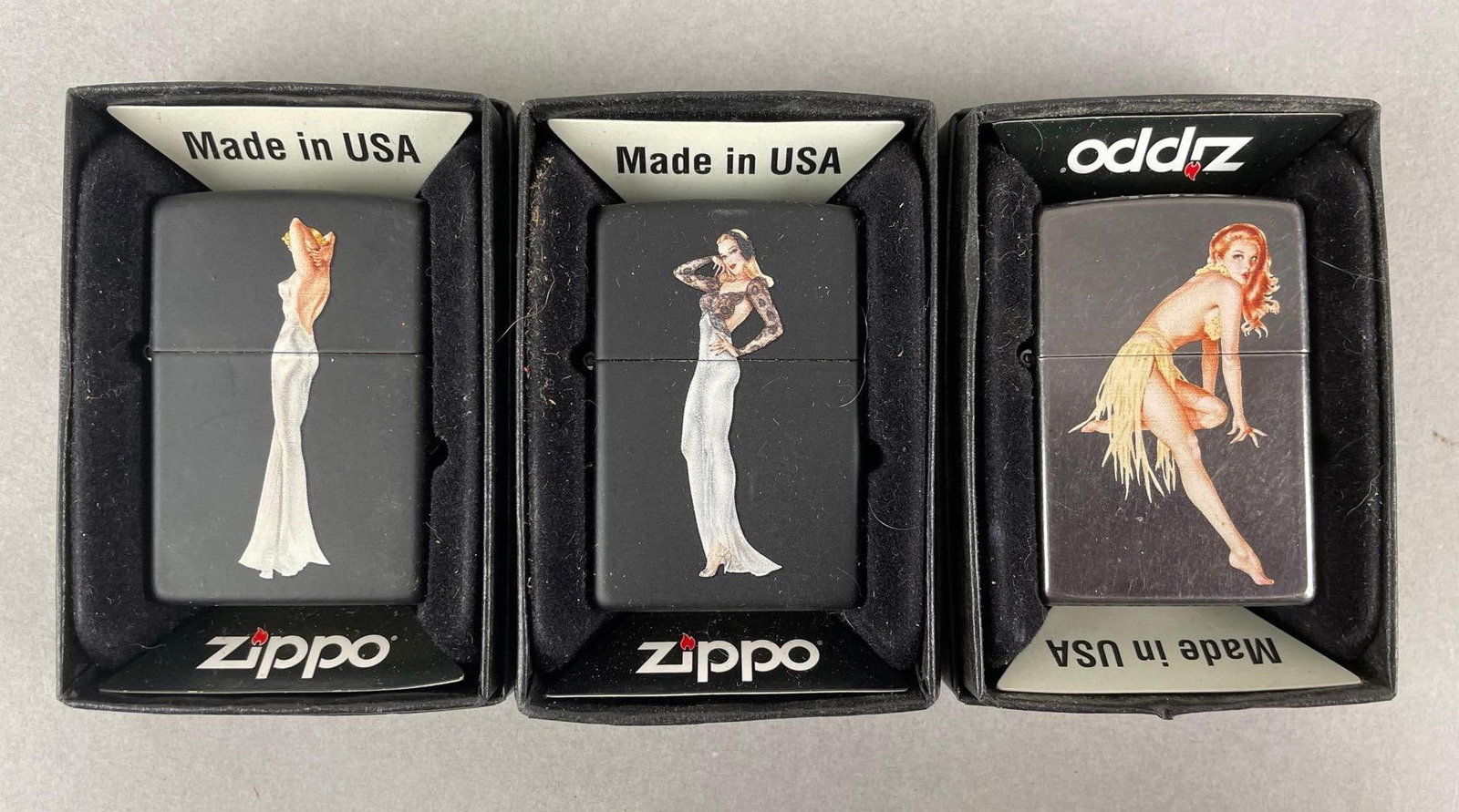 Group of 3 Limited Edition Pin-Up Zippo Lighters: Includes numbers 034, 036, 033 of 100. Each sealed with stickers and original boxes. Each measure 2 1/4 x 1 1/2 inches