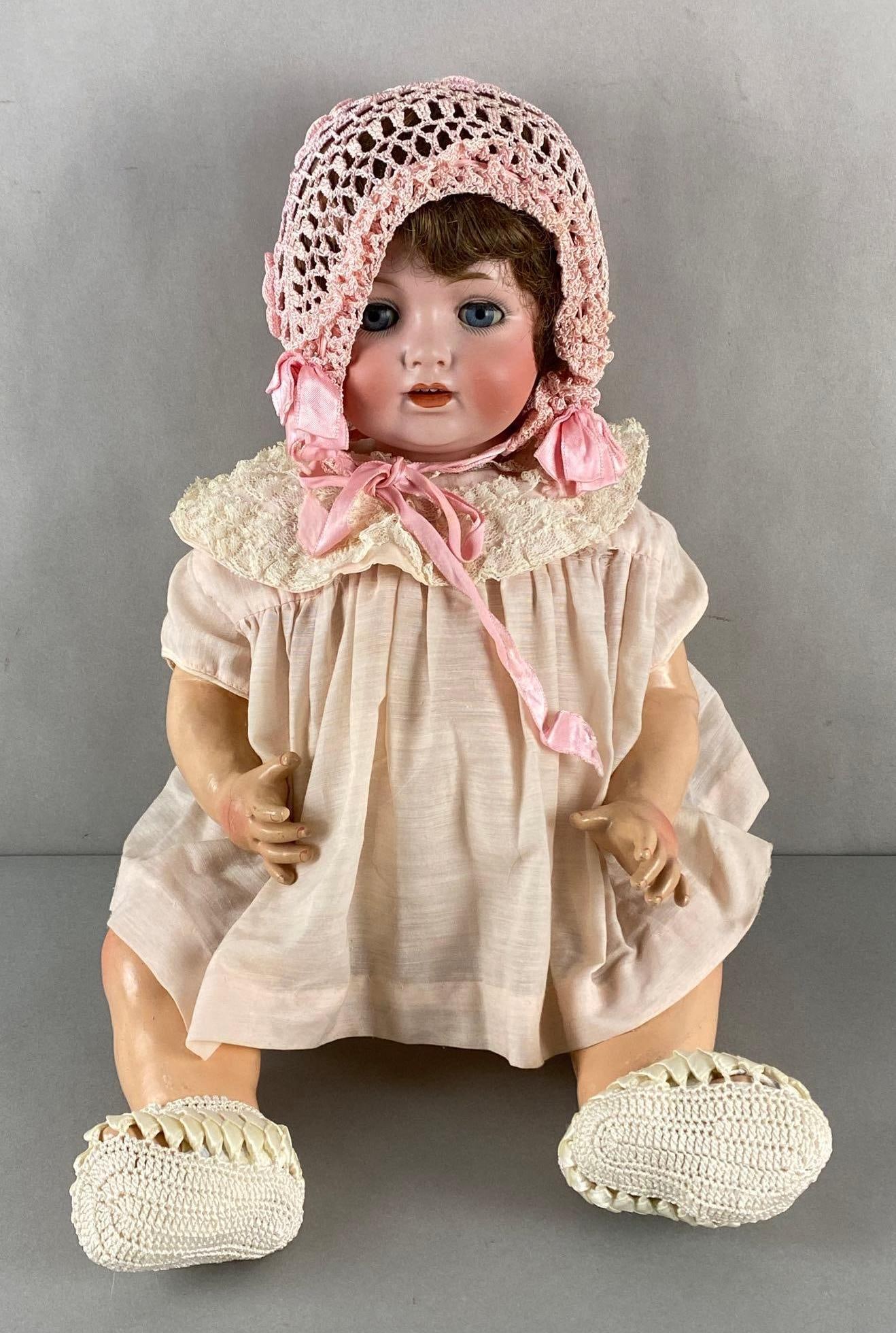 Antique German Porcelain Baby Doll: Marked Germany 55/60 on back of neck, Composite body and limbs, Some cracks, Eyes open and close, Measures 21 1/2 inches tall.