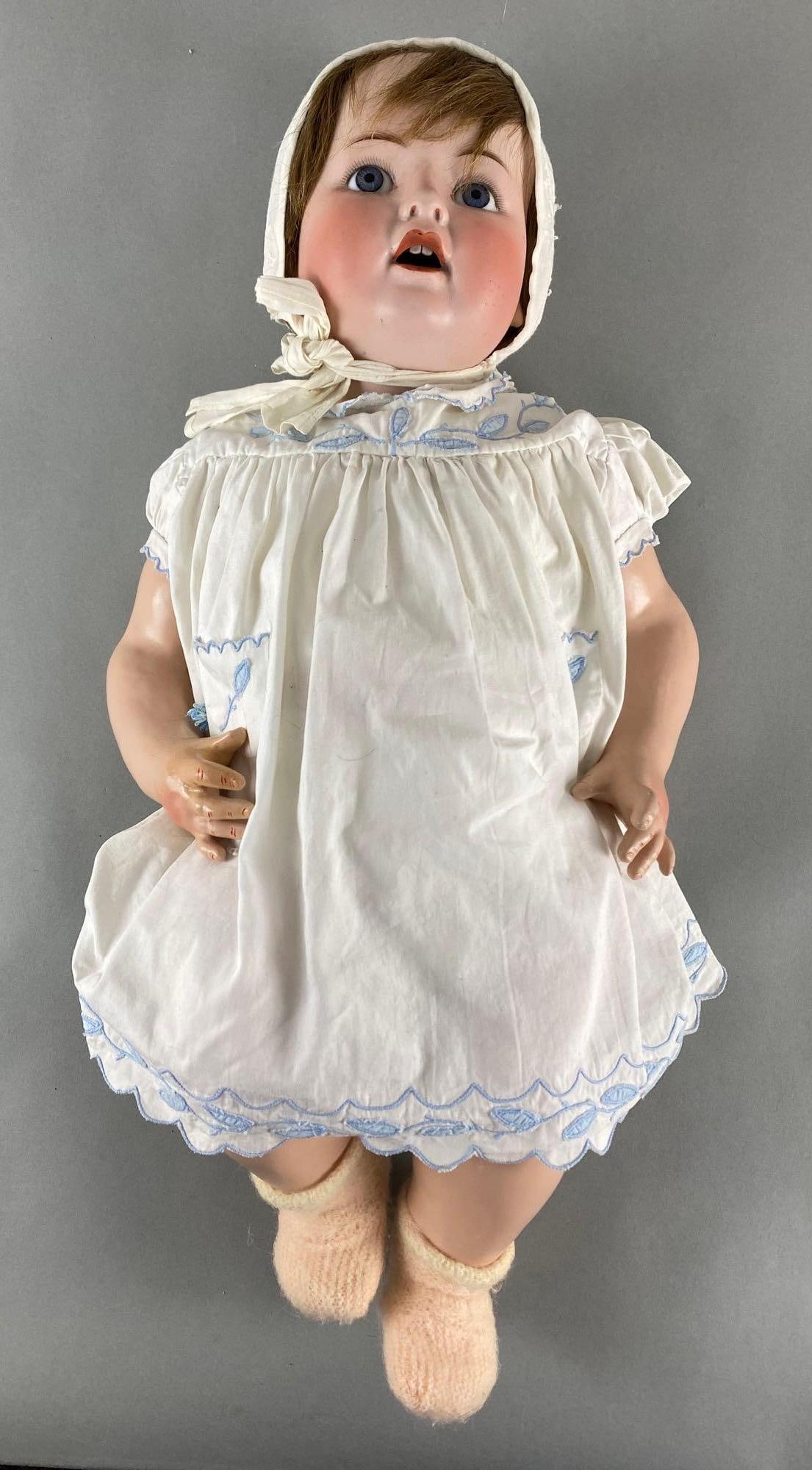 Antique German Porcelain Baby Doll: Marked Germany b5-12 on back of neck, Composite body and limbs, Finger repair on right hand, Open eyes, Measures 22 1/2 inches tall.