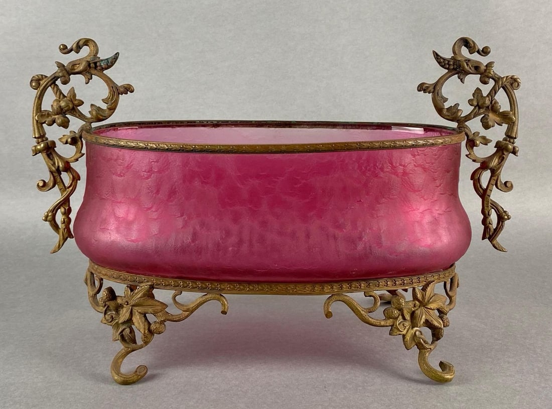 Legras Mont Joye Cranberry Glass Ovoid Centerpiece: With cast metal floral feet and handles, Some tarnishing, One or two small chips, Measures 9 1/2 x 15 x 7 inches.