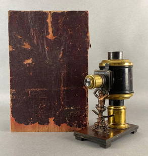 Antique German Magic Lantern Projector with Slides: Unknown working condition, With some glass slides, With wood carrying case, Case with some tears and cracks, Case measures 13 1/2 x 9 x 5 3/4 inches.