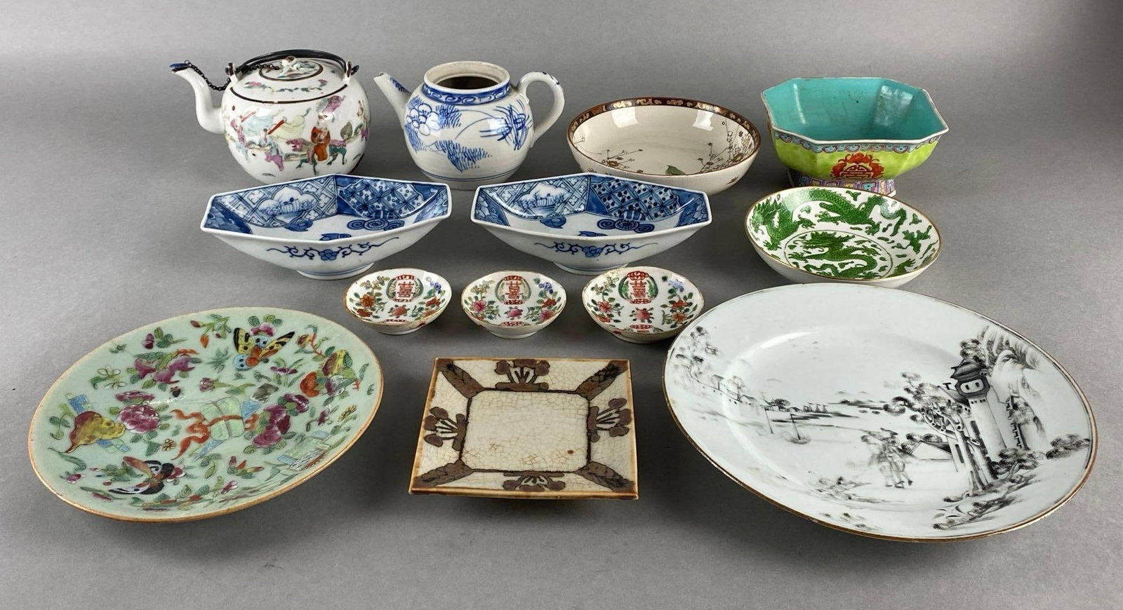 Group of 13 Assorted Porcelain Asian Painted Plates and More: Includes teapots, platted, serving dishes, and more, Some chips and cracks throughout, Largest measures 9 1/4 x 9 1/4 x 1 1/4 inches.