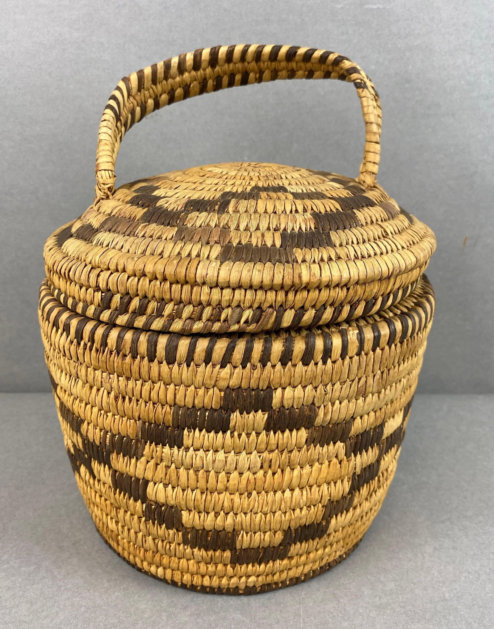 Woven Basket with Handle: Handle not fully taught to lid, measures 10 x 7 x 7 inches