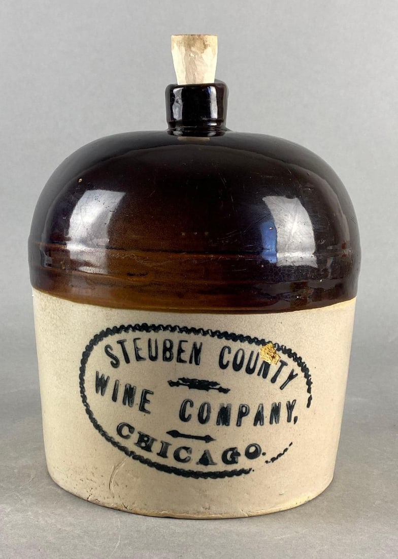 1 Gallon Chicago Illinois Steuben County Wine Company Stoneware Jug: Small chip on front of jug, Measures 9 3/4 x 8 x 8 1/2 inches.