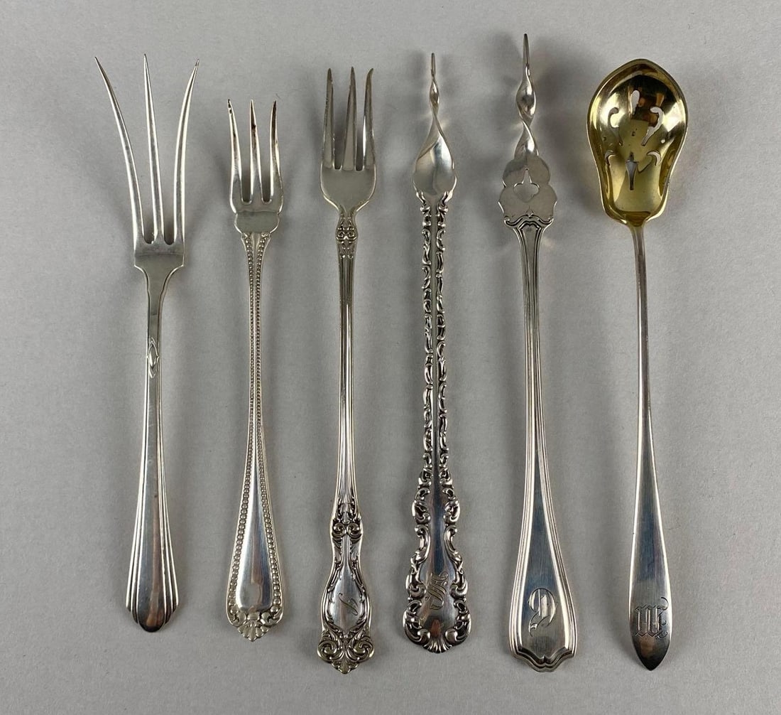 Group of 6 Sterling Silver Serving Utensils: Total weight 91.2g, Includes Butter Pat Picks, Olive Spoon, Pickle Forks, and Lemon Fork, Some with engraved initials, Some handles turn down, Longest measures 6 1/4 inches long.