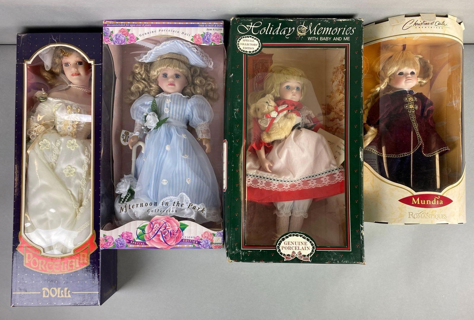 Group of 5 Assorted Porcelain Dolls: Includes Mundia, holiday Memories, Victorian rose and more, like new in original boxes, tallest measures 22 inches