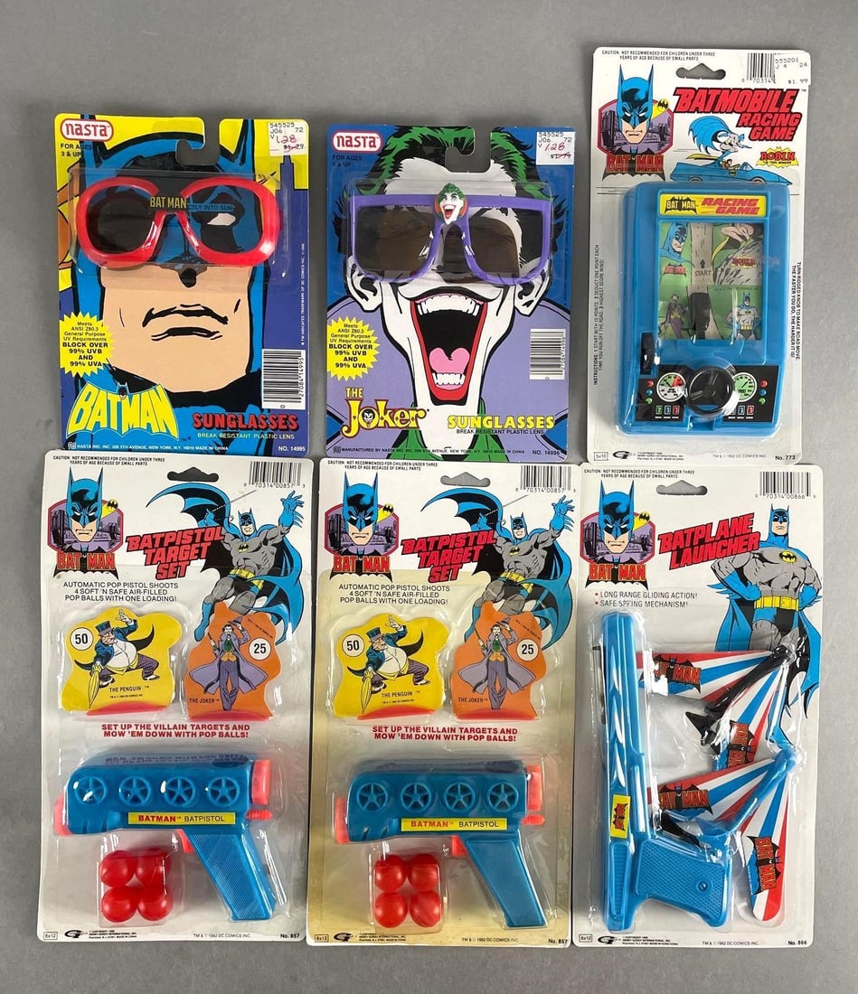 Group of 6 1980s Batman Toys: Includes guns, sunglasses, racing game. Lens out of glasses. Largest original packaging measures 12 x 6 1/2 inches
