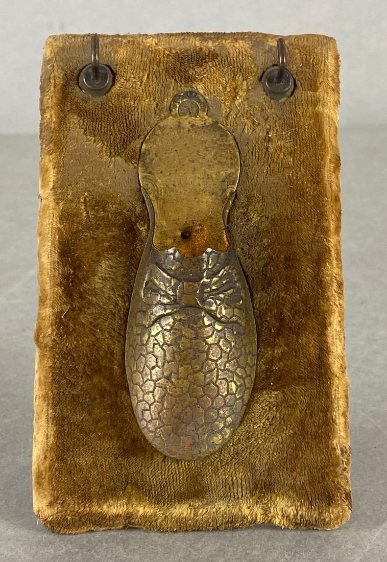 Standing Pressed Tin Shoe Matchstick Holder: Mounted on fabric backing, Measures 5 x 3 1/4 x 1 1/2 inches.