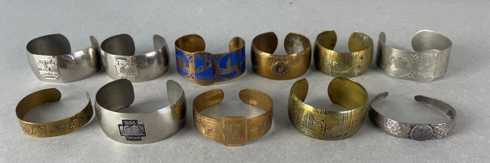 Group of 11 1933-34 Chicago Worlds Fair Metal Cuff Bracelets: Blue and copper bracelet measures 2 1/2 x 2 x 1 1/4 inches