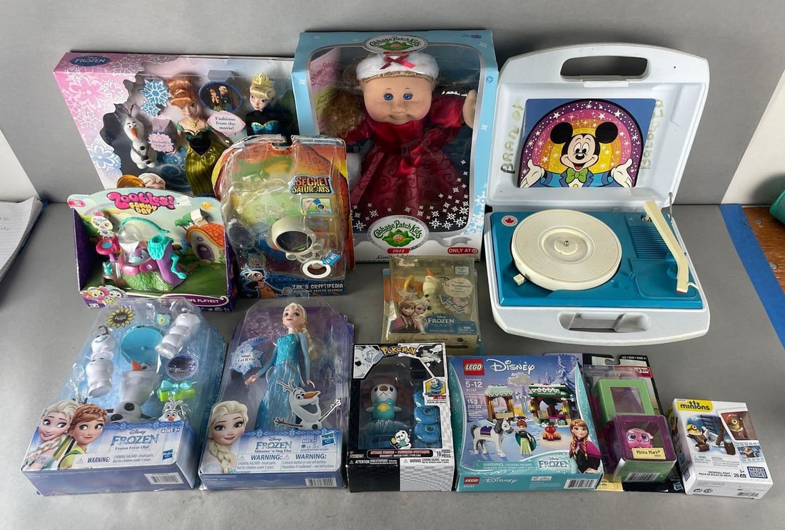 Group of Disney Fashion Dolls and More: Includes Mickey Mouse toy record player, 2012 Christmas cabbage patch kid, Pokémon figure, some damaged packaging. Largest measures 15 x 12 x 5 inches
