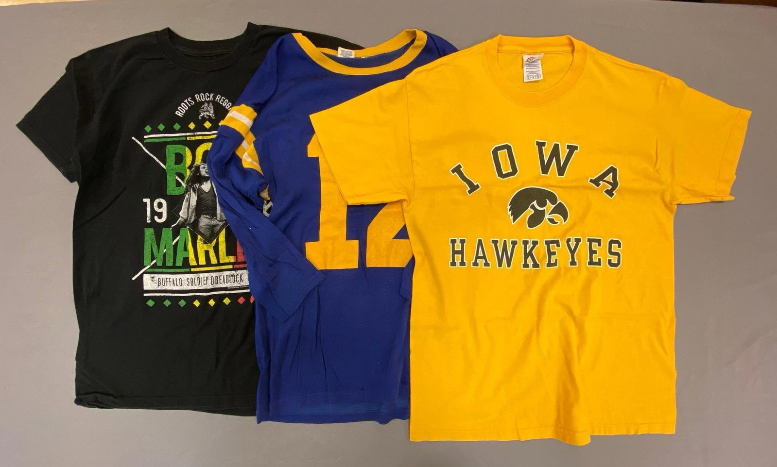 Group of 3 T-Shirts and Long Sleeve Shirts: Includes 1980 Bob Marley t-shirt Size M, Iowa Hawkeyes t-shirt Size M, and Campbell #12 t-shirt jersey size S.