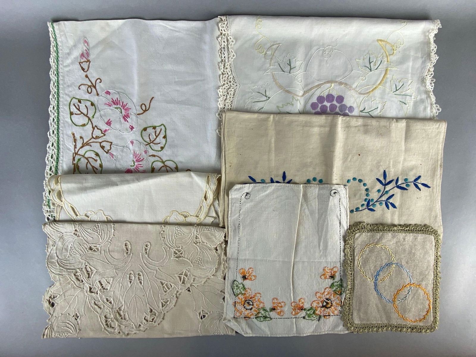 Group of 7 Embroidered Linen Table Runners and More: Includes table runners, table squares, hand towel, and more, Largest measures 27 1/2 x 27 1/2 inches.