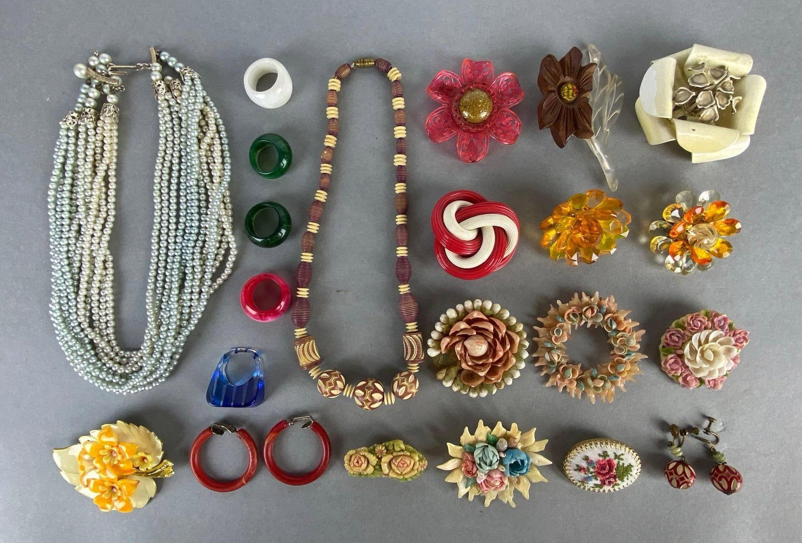 Group of 20+ Costume Jewelry: Includes necklaces, brooches, earrings, and rings, Includinf beaded, plastic, shell, embroidered, and more, Longest measures 15 1/2 inches long.