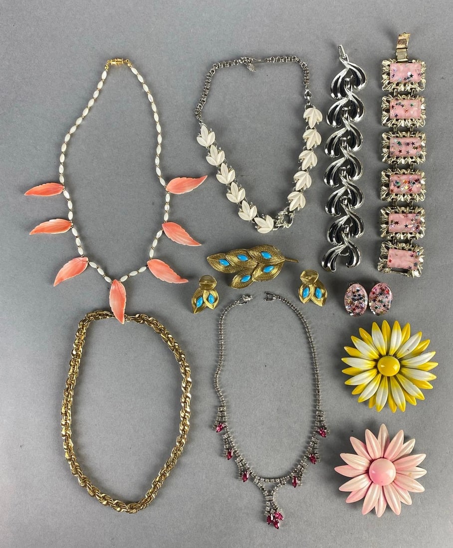 Group of 11 Costume Jewelry Items: Includes necklaces, earrings, bracelets, and brioches, Including acrylic, rhinestone, and more, Some broken clasps and missing pieces, Longest necklace measures 16 inches long.