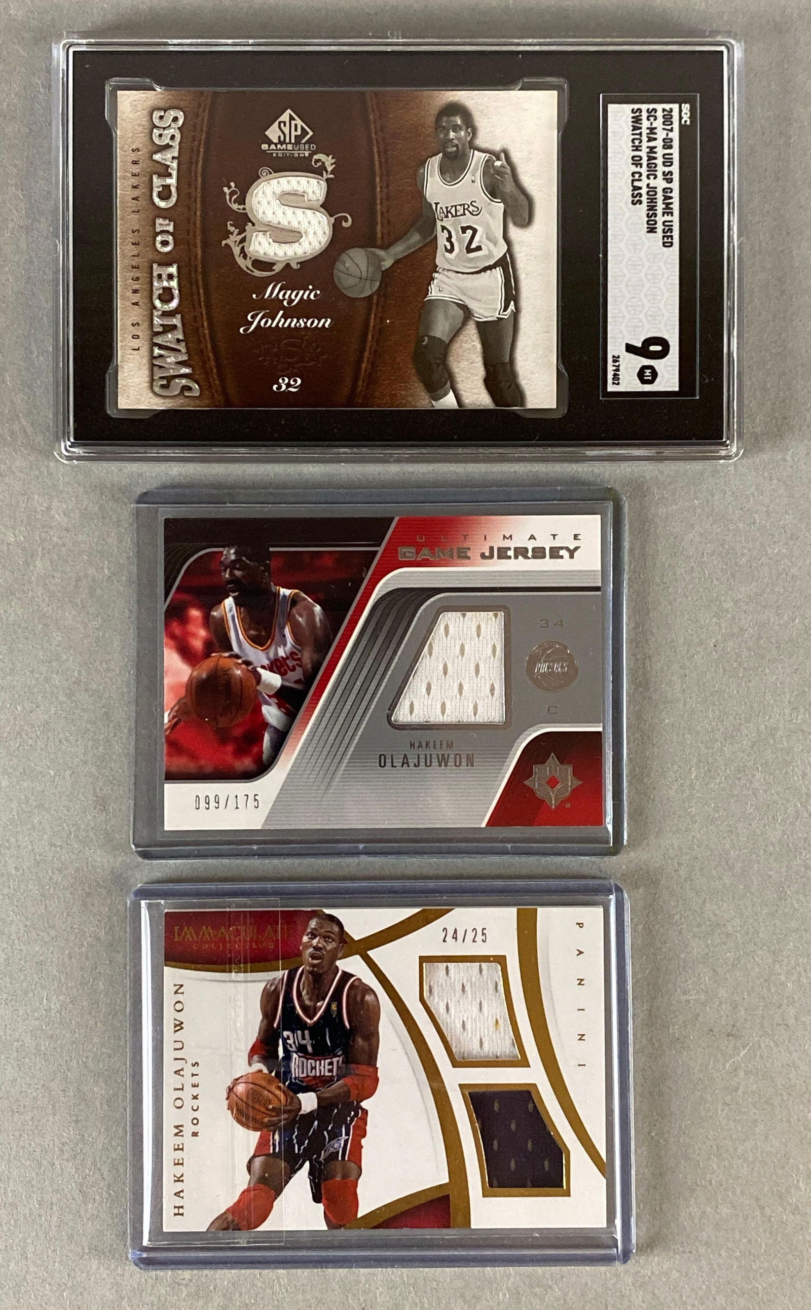 2007 Sp Game Used Magic Johnson #SC-MA Swatch of Class SGC 9 + 2 - Olajuwon Jersey Cards: 2004 Ultimate Collection Jersey Hakeem Olajuwon #UGJ-HO , 2014 Immaculate Collection Jersey Hakeem Olajuwon #DM-HK 24/25