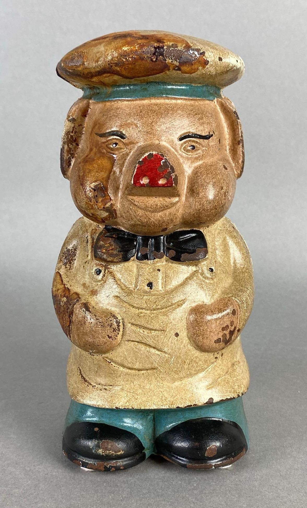 Cast Iron Chef Piggy Bank Coin Bank: Some paint chipping and paint loss, Measures 7 1/2 x 4 x 4 inches.