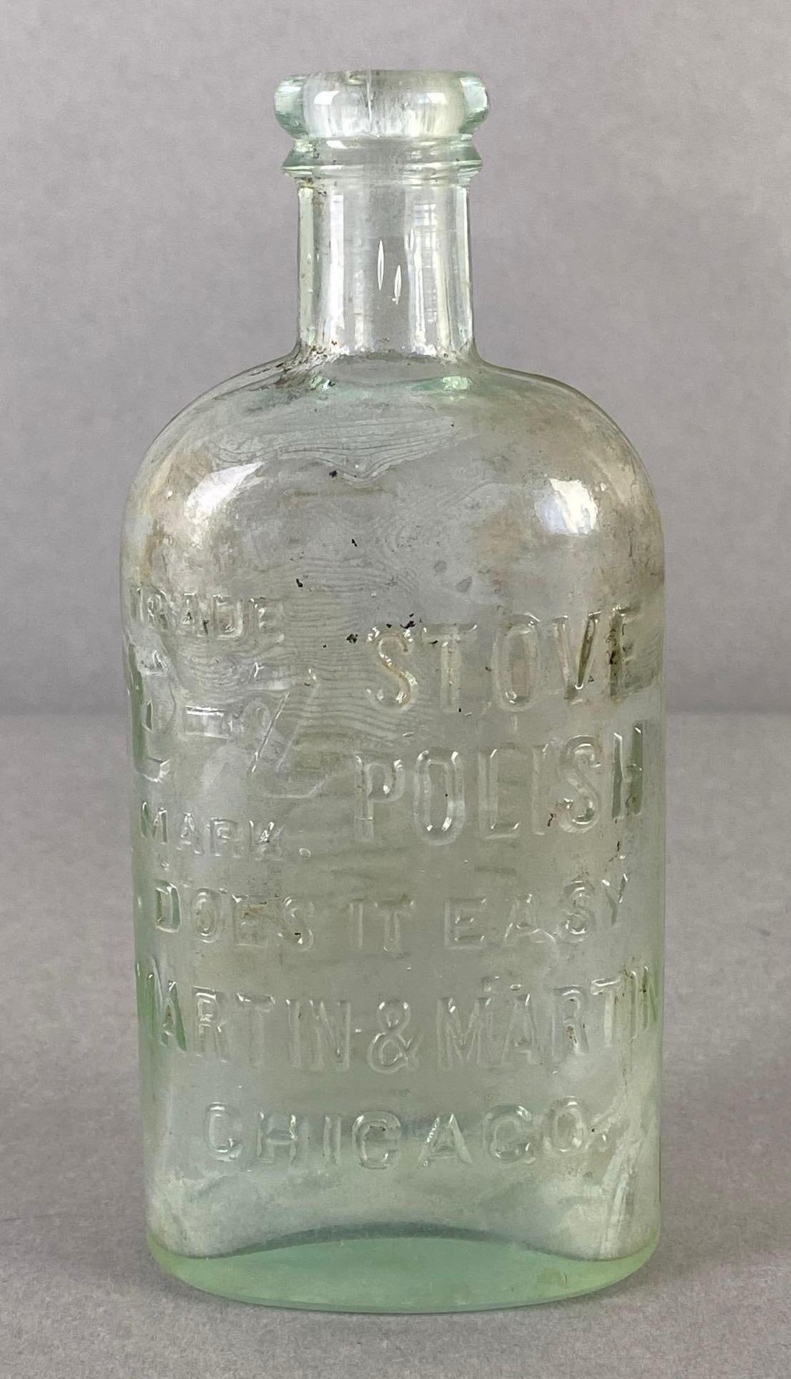 Martian and Martian Chicago E-Z Stove Polish Embossed Clear Glass Advertising Bottle: Some debris on inside, Measures 6 x 2 3/4 x 3 3/4 inches.