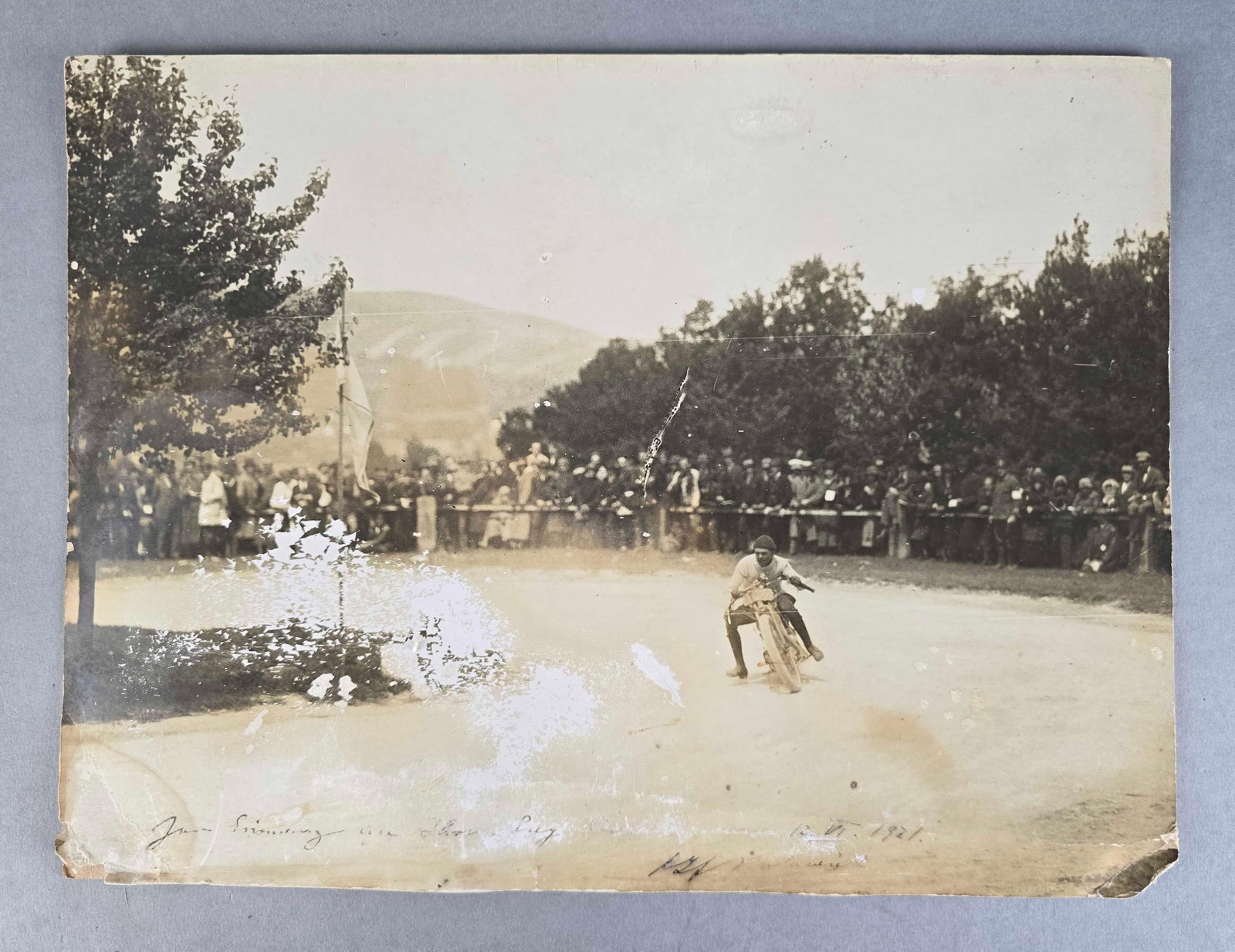 1921 Motorcyle Racer Photograph on Board: Shows racer taking a steep turn, writing and date on bottom, measures 15 1/2 x 11 3/4 inches