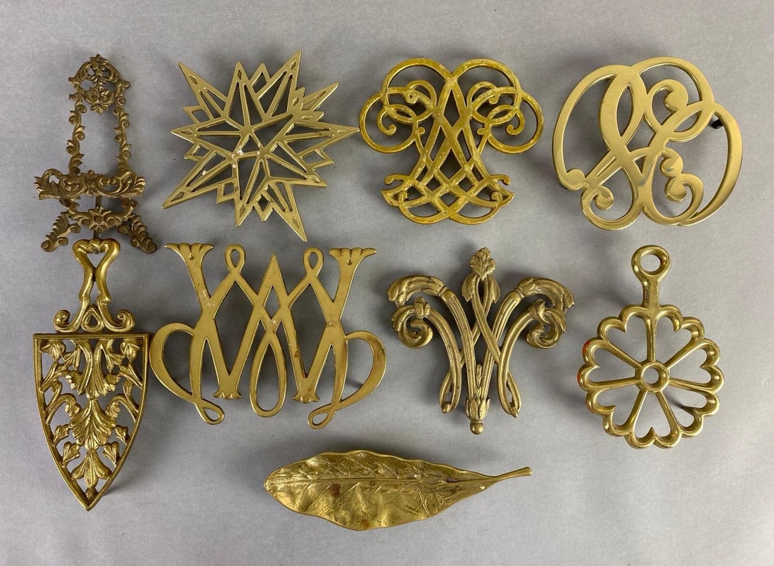 Group of Brass Trivets and More: Includes trivets, iron trivet, leaf trinket dish, miniature easel, and more, Largest measures 6 1/4 x 8 x 3/4 inches.