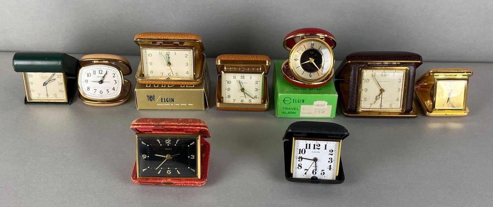 Group of 9 Travel Clocks: Untested, includes Elgin, Semca, Bulova and more, some in original boxes, largest measures 4 x 4 x 1 1/2 inches