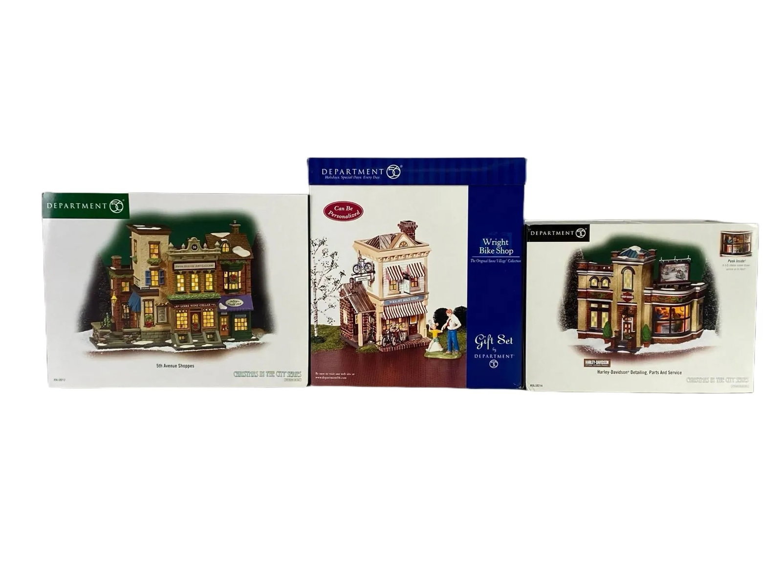Group of Department 56 Christmas Village Buildings and More: Includes 5th Avenue Shoppes, Wright Bike Ship, and Harley-Davidson Detailing Parts and Service, In original boxes, Largest box measures 9 1/2 x 12 1/2 x 8 inches.
