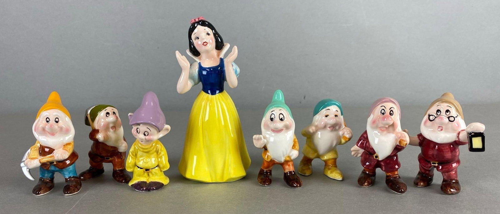Set of 8 Disney Snow White Porcelain Figures: Dwarfs and Snow White. Measures 5 1/4 x 2 3/4 x 2 1/2 inches.